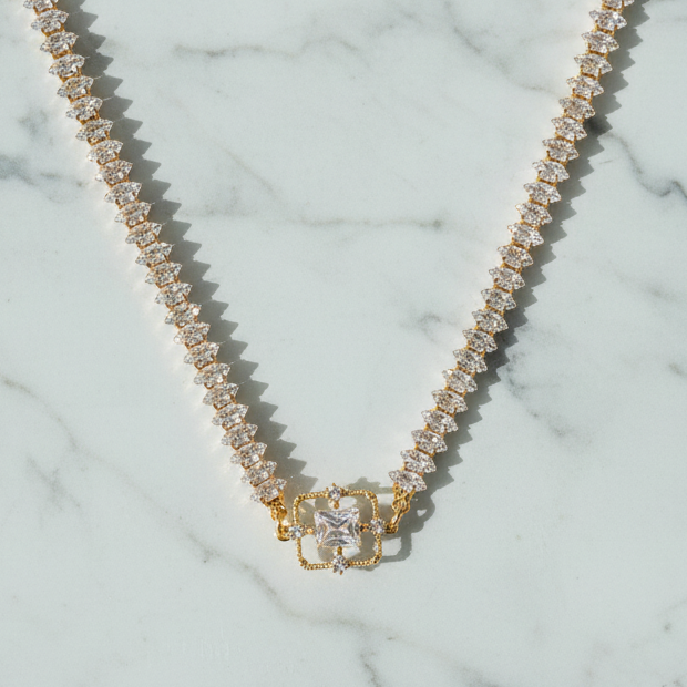 Gold necklace with a clasp on a marble surface