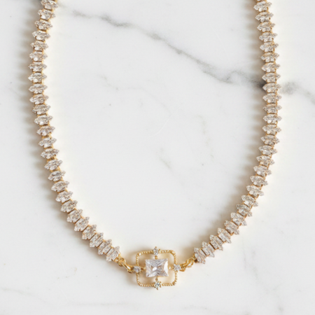 Pearl necklace with a gold clasp on a marble background