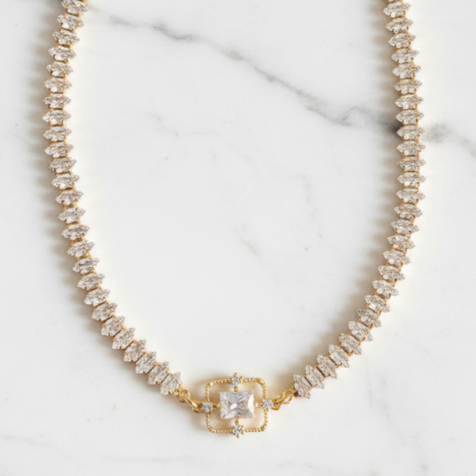 Pearl necklace with a gold clasp on a marble background