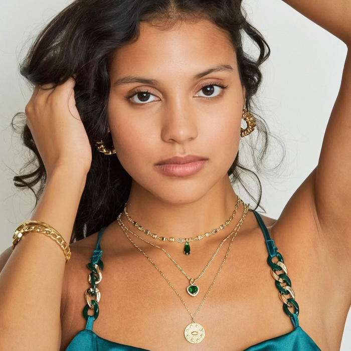 Woman wearing gold jewelry with a plain background