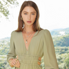 Woman wearing a green jumpsuit with a scenic background