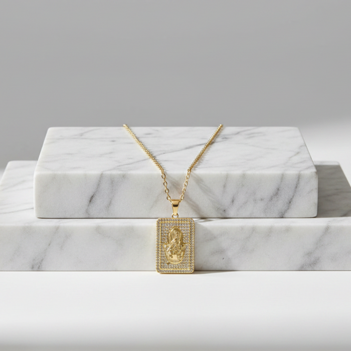 Gold necklace with a pendant on a marble surface