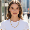 Woman wearing a gold chain necklace in an urban setting