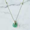 Necklace with a green pendant on a marble background