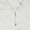 Gold necklace with a pendant on a marble background