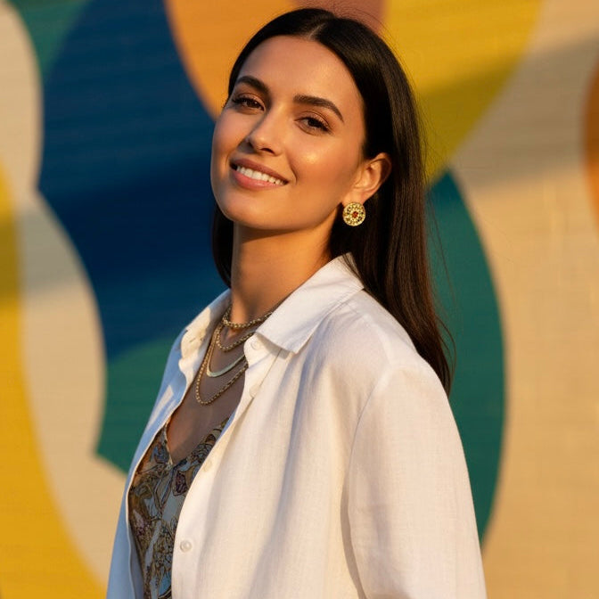 Woman in a white shirt standing in front of a colorful abstract wall.