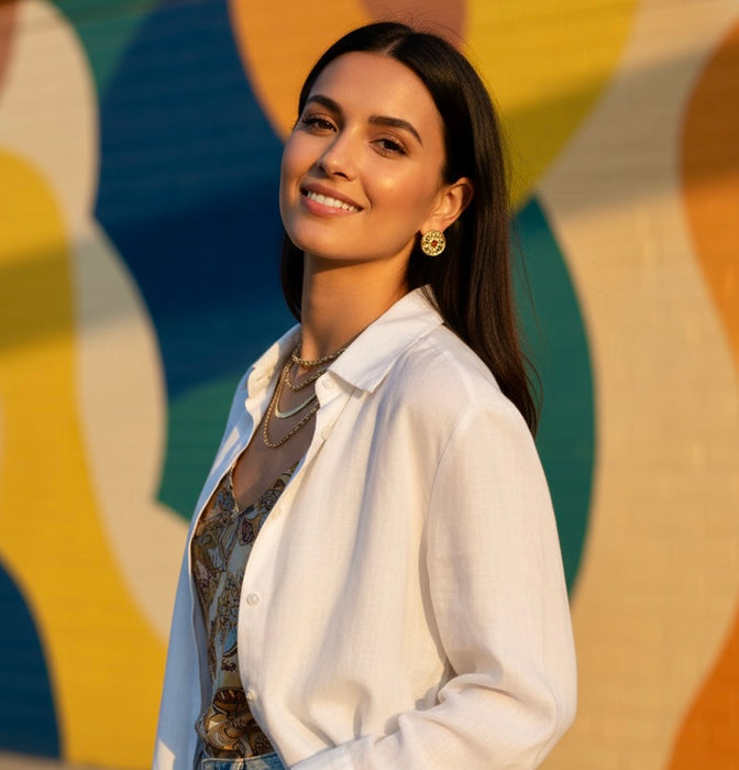 Woman in a white shirt standing in front of a colorful abstract wall.