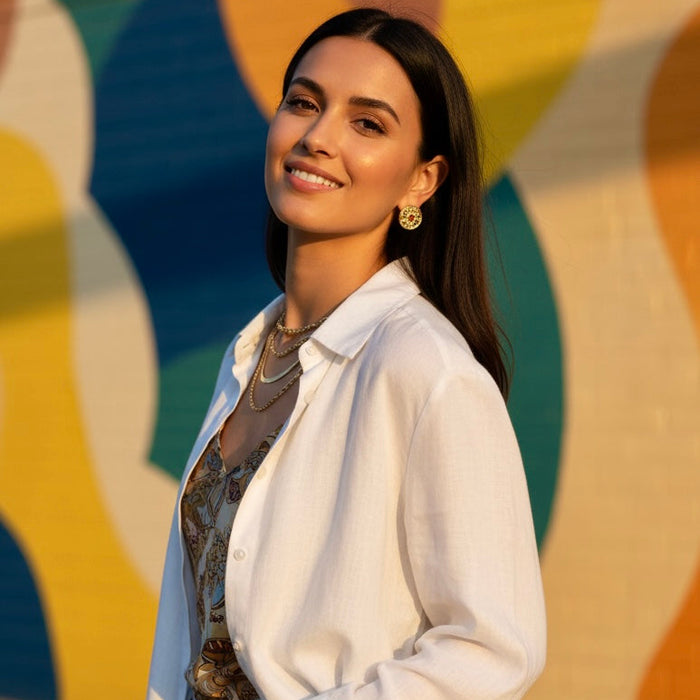 Woman in a white shirt standing in front of a colorful abstract wall.