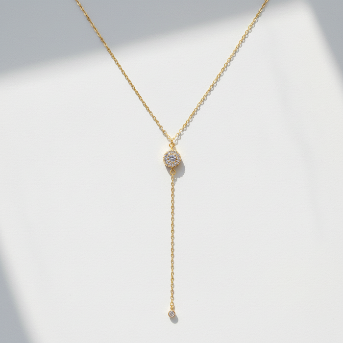 Gold necklace with a y-style clasp on a light gray background