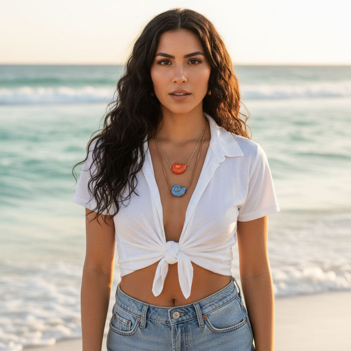 Woman in a white top and denim shorts standing on a beach.
