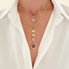 Gold necklaces with gemstones on a white shirt background