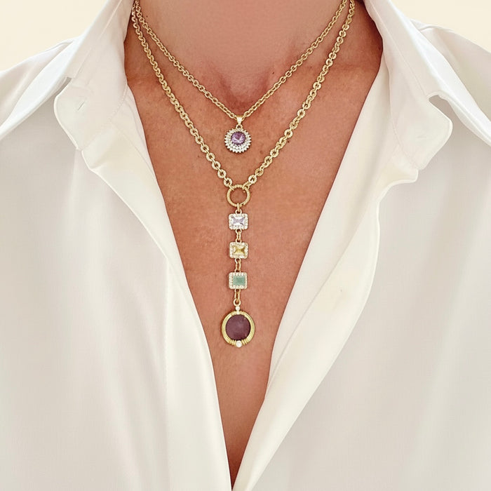 Gold necklaces with gemstones on a white shirt background