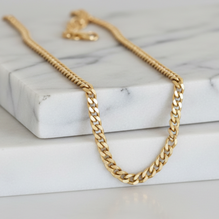 Gold chain necklace on a marble surface