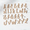 Gold alphabet letter pendants on a white background