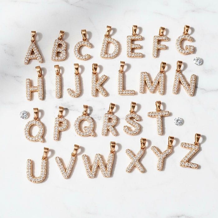 Gold alphabet letter pendants on a white background