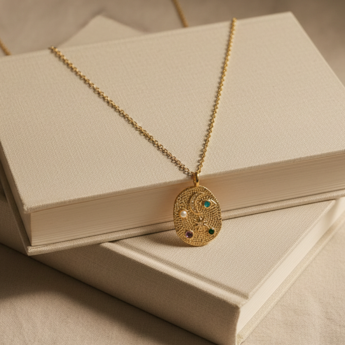 Gold necklace with a pendant on a beige book