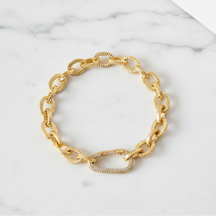Gold chain bracelet on a marble surface