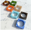 Set of colorful square-shaped bangles on a marble surface