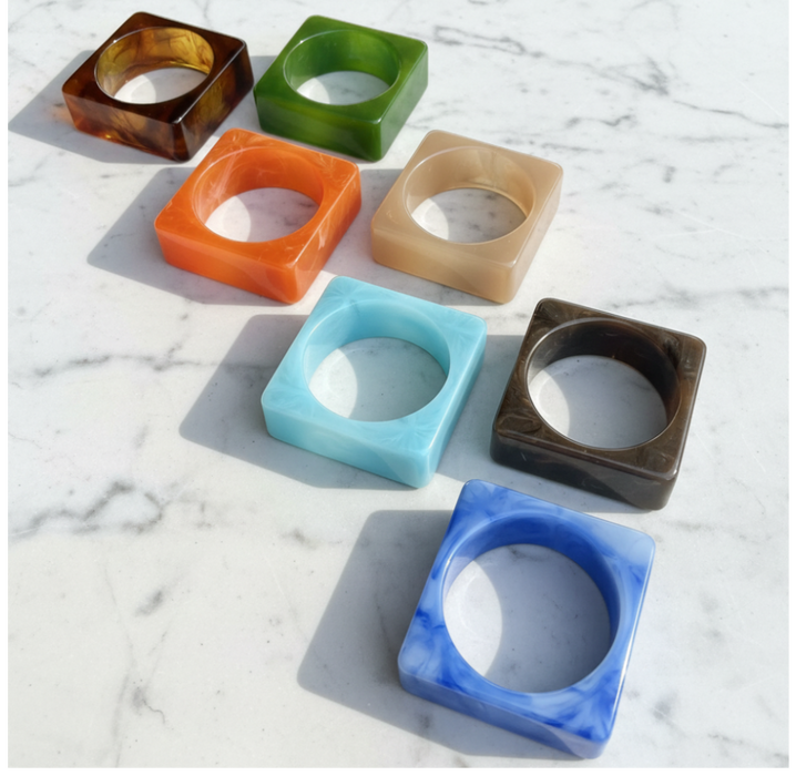 Set of colorful square-shaped bangles on a marble surface