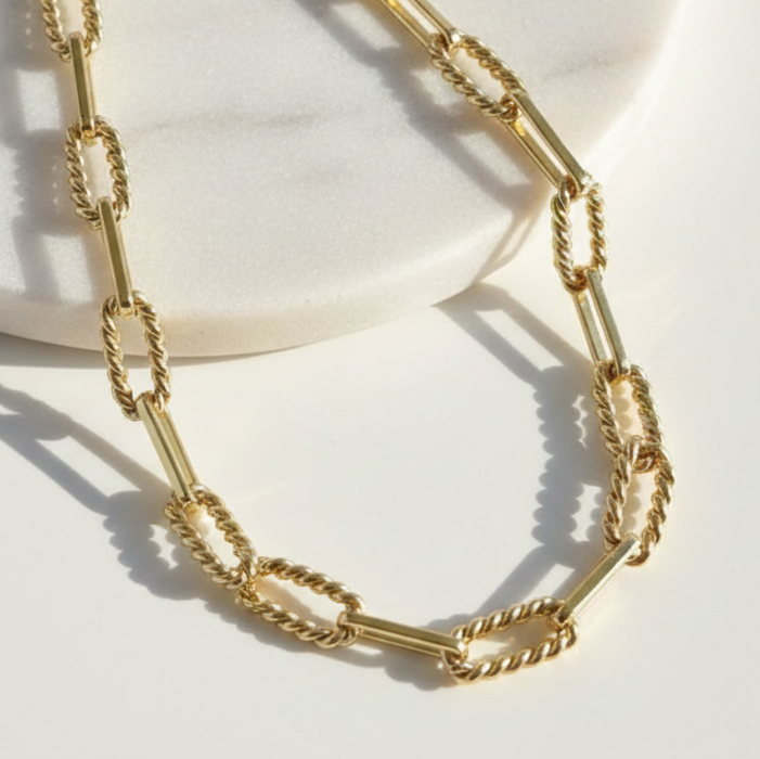 Gold chain necklace on a light background