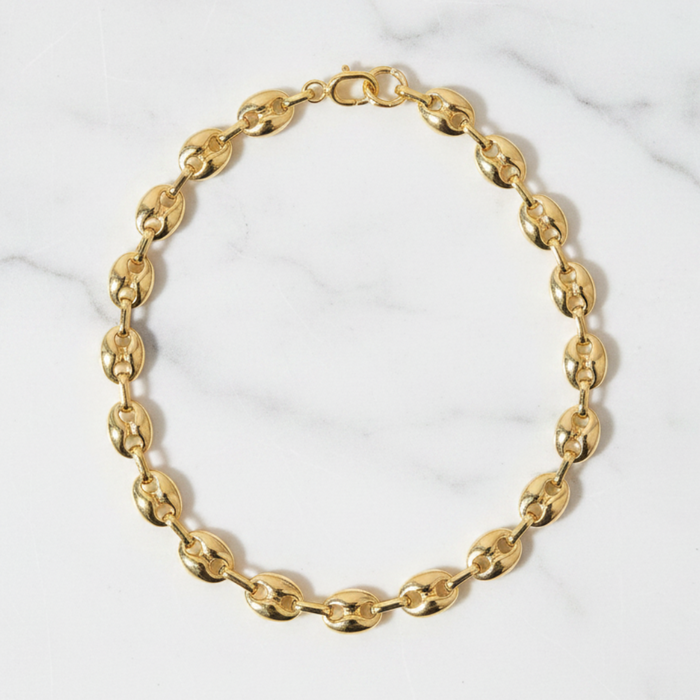 Gold chain bracelet on a marble surface