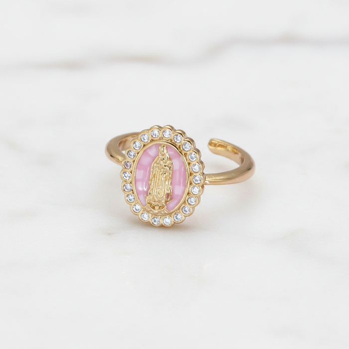 Gold ring with pink center and gemstones on a white background
