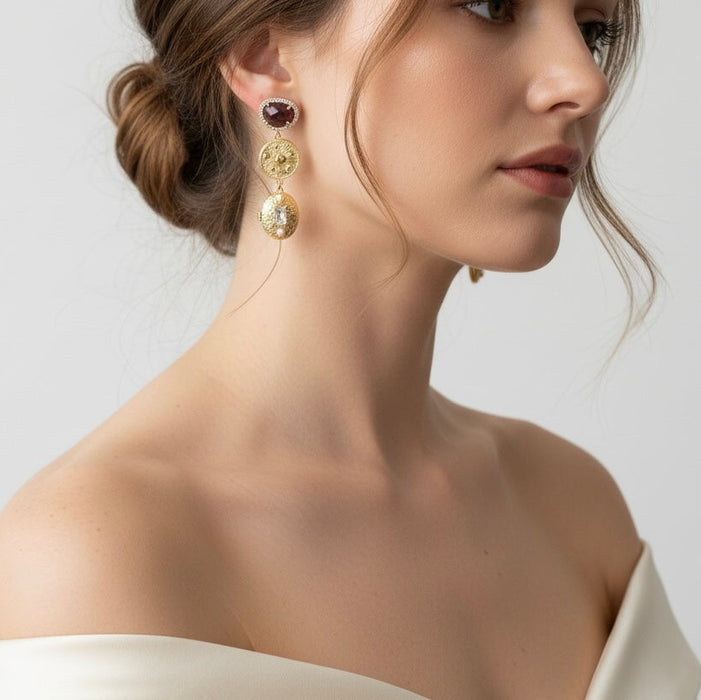 Close-up of a woman wearing gold earrings with a neutral background