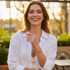 Woman in a white shirt standing outdoors with a blurred background