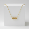 Gold necklace on a white box with a white background