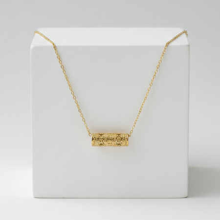 Gold necklace on a white box with a white background