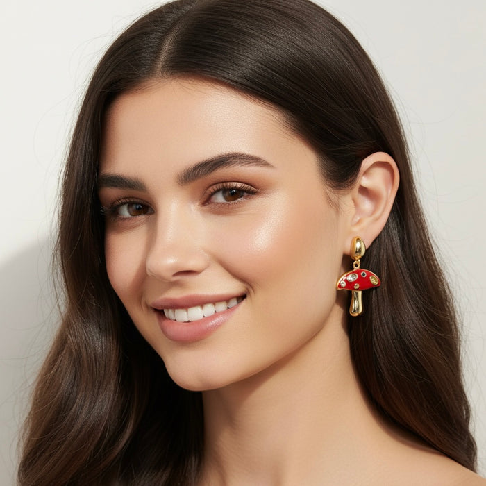 Woman wearing a gold earring with a red gemstone against a neutral background