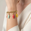 Bracelet with colorful charms on a wrist against a neutral background