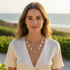 Woman wearing a gold necklace with a scenic background