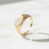 Gold ring with a white stone on a light background