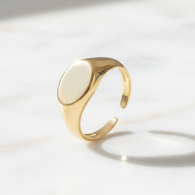 Gold ring with a white stone on a light background
