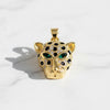 Gold leopard pendant with gemstones on a white background