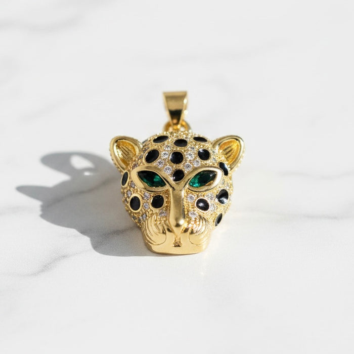 Gold leopard pendant with gemstones on a white background