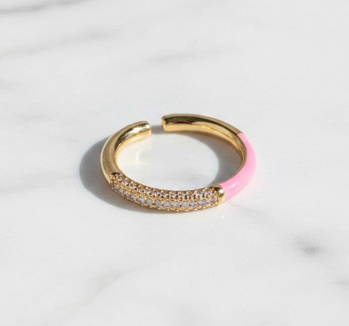 Gold hoop ring with pink accent on a light gray background
