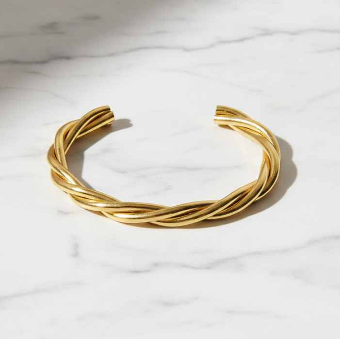 Gold bracelet on a marble surface
