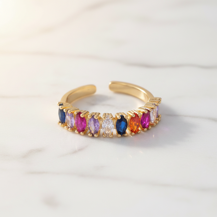 Gold ring with multicolored gemstones on a white background