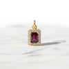 Gold pendant with a red gemstone on a white background