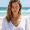 Woman wearing a necklace with a pendant on a beach