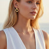 Woman wearing gold hoop earrings with a blurred background