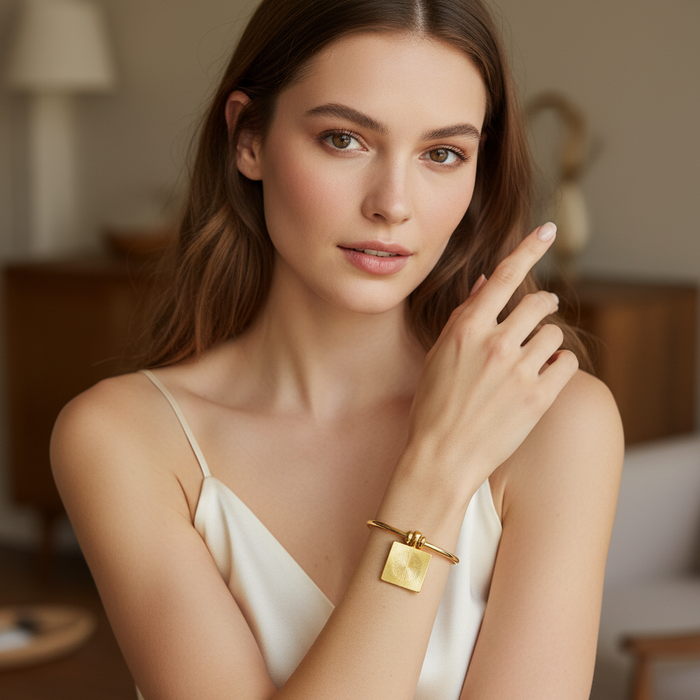 Woman wearing a gold bracelet in an indoor setting