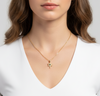 Woman wearing a gold necklace with a star-shaped pendant on a plain background
