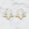 Gold hoop earrings on a marble surface