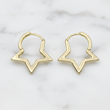 Gold hoop earrings on a marble surface