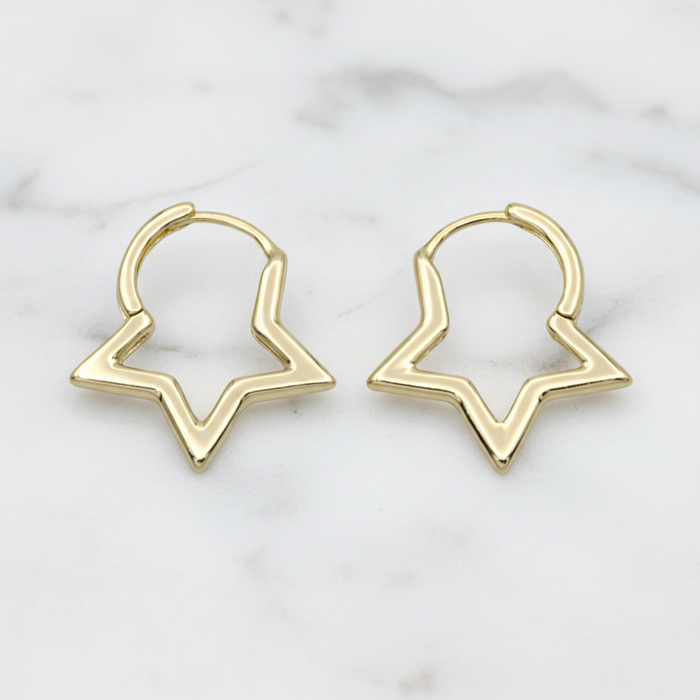 Gold hoop earrings on a marble surface