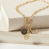 Gold necklace with charms on a white surface