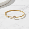 Gold bracelet with a heart-shaped diamond on a white surface
